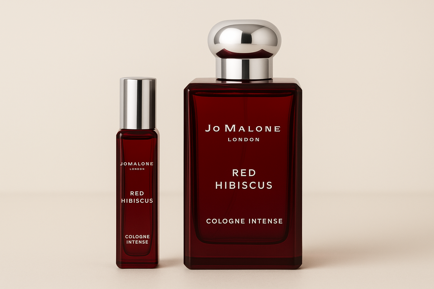 Jo Malone Red Hibiscus Cologne Intense 12 ml-prov bredvid en 100 ml parfymflaska med Jo Malone Red Hibiscus Cologne Intense som har vit text på den mörkröd flaskan.